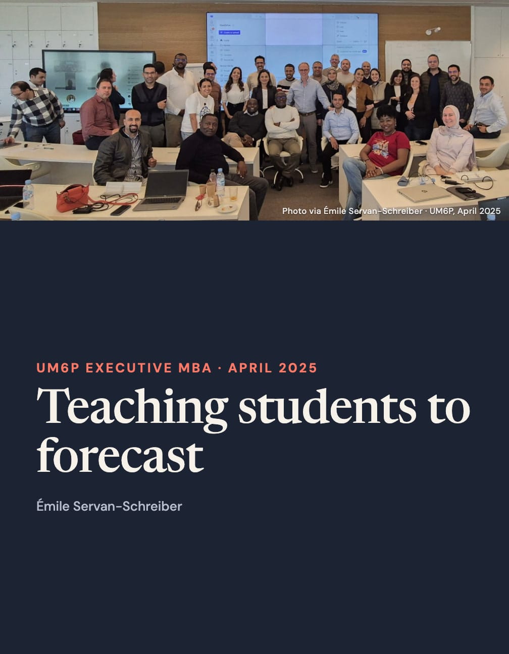 The same whole classroom group photo above a navy panel reading “UM6P Executive MBA · April 2025”, “Teaching students to forecast” and “Émile Servan-Schreiber”.